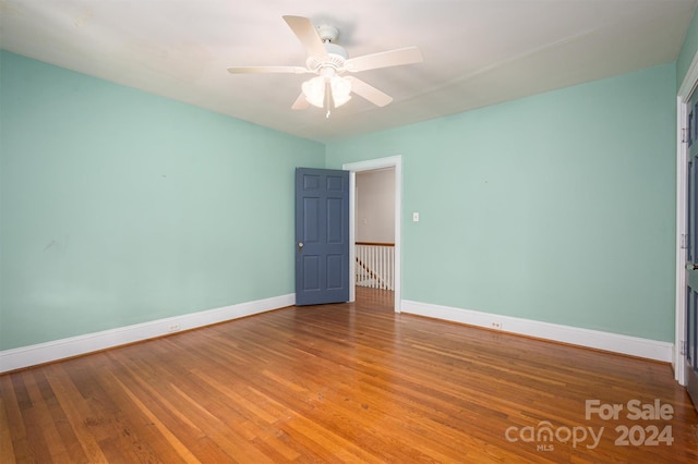 spare room featuring hardwood / wood-style floors and ceiling fan