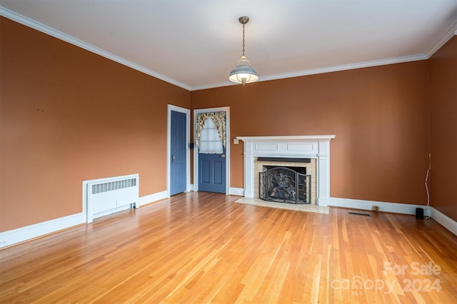 unfurnished living room featuring radiator heating unit, ornamental molding, and light hardwood / wood-style flooring