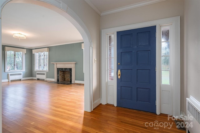 foyer featuring radiator heating unit, hardwood / wood-style flooring, and plenty of natural light