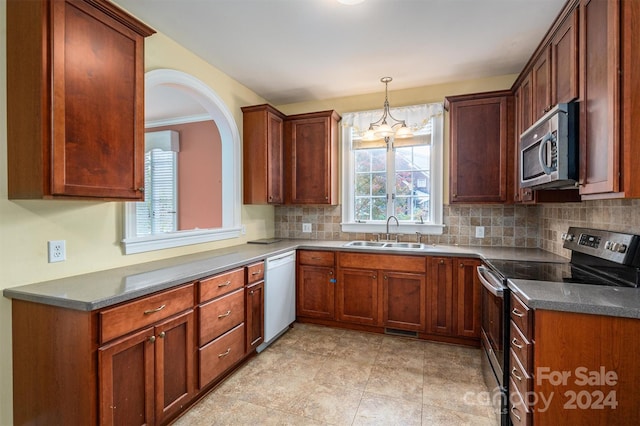 kitchen featuring stainless steel appliances, sink, a chandelier, crown molding, and backsplash