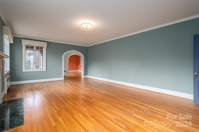 empty room with ornamental molding and hardwood / wood-style floors