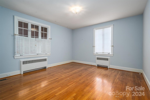 spare room with hardwood / wood-style flooring and radiator