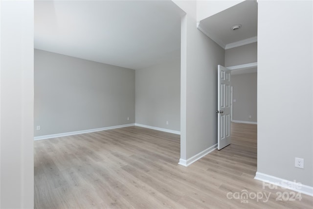 spare room featuring light hardwood / wood-style floors and ornamental molding