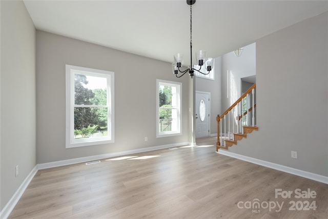 foyer entrance featuring light hardwood / wood-style floors and an inviting chandelier