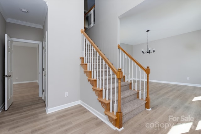 stairs featuring a notable chandelier, wood-type flooring, and ornamental molding