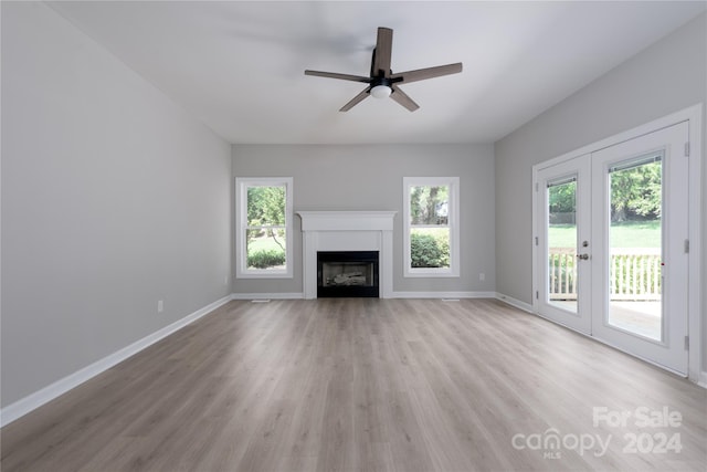 unfurnished living room featuring french doors, ceiling fan, and light wood-type flooring