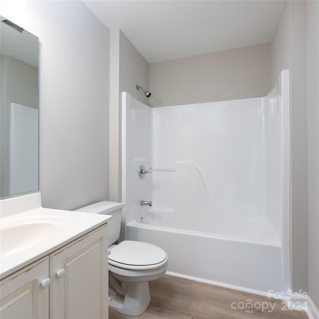 full bathroom featuring bathtub / shower combination, vanity, hardwood / wood-style floors, and toilet