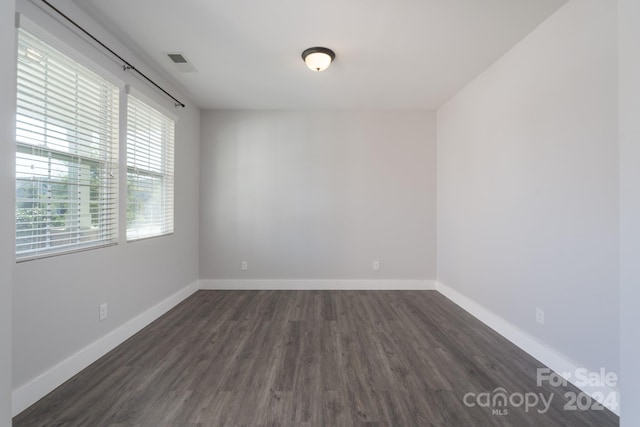 unfurnished room with dark hardwood / wood-style flooring