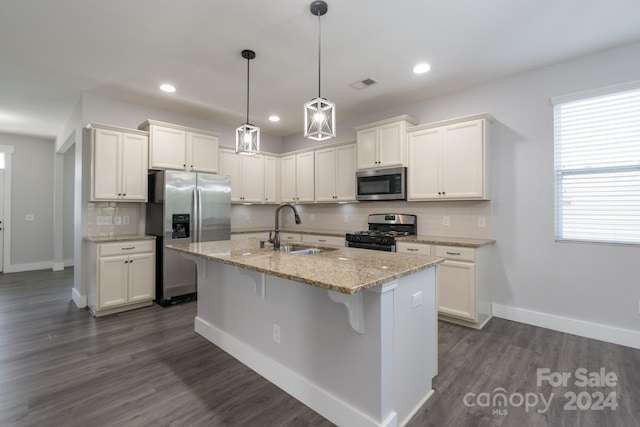 kitchen featuring an island with sink, white cabinets, dark hardwood / wood-style flooring, stainless steel appliances, and sink