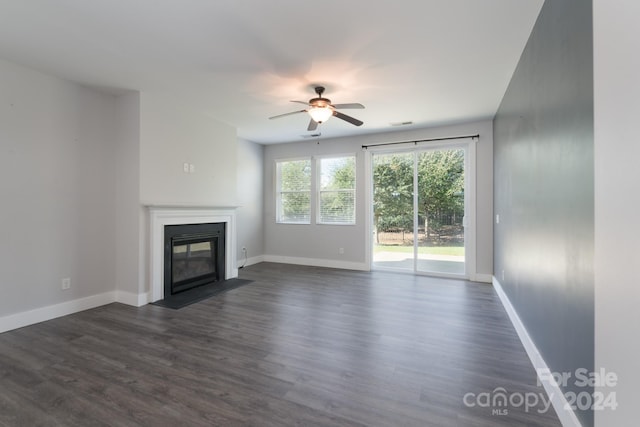 unfurnished living room featuring ceiling fan and dark hardwood / wood-style flooring