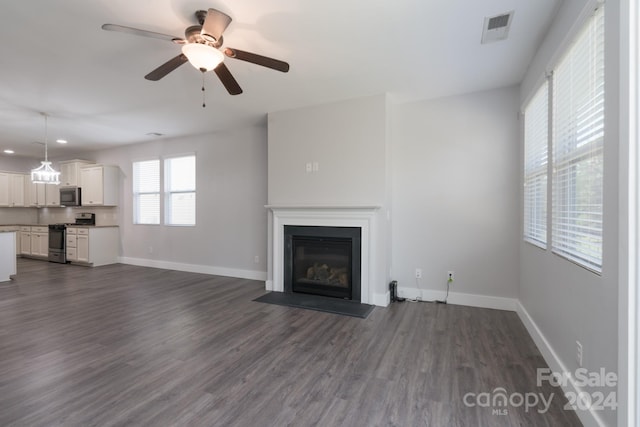 unfurnished living room featuring ceiling fan and dark hardwood / wood-style floors