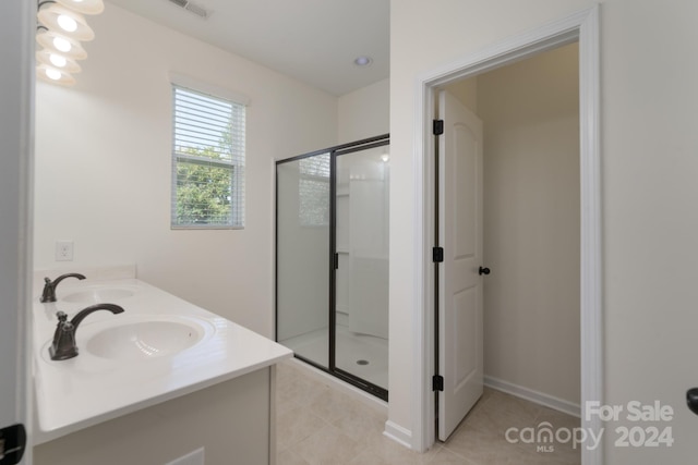 bathroom with walk in shower, vanity, and tile patterned flooring