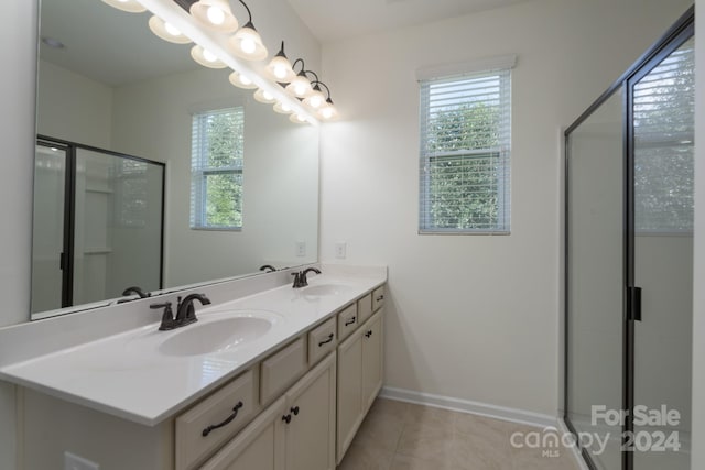 bathroom with walk in shower, vanity, and tile patterned floors