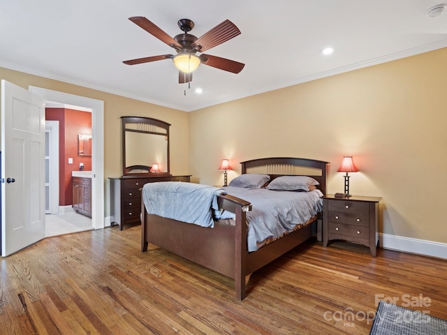 bedroom featuring hardwood / wood-style flooring, crown molding, ceiling fan, and ensuite bath