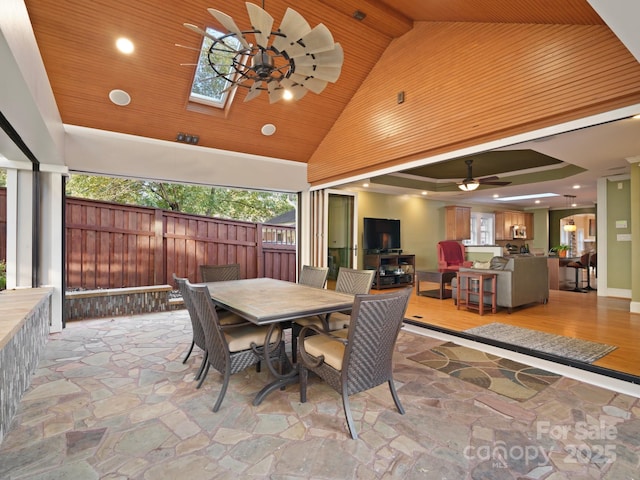 dining space featuring high vaulted ceiling, wood ceiling, ceiling fan, and a skylight