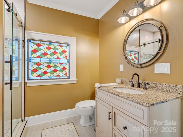 bathroom featuring crown molding, a shower with shower door, vanity, and toilet