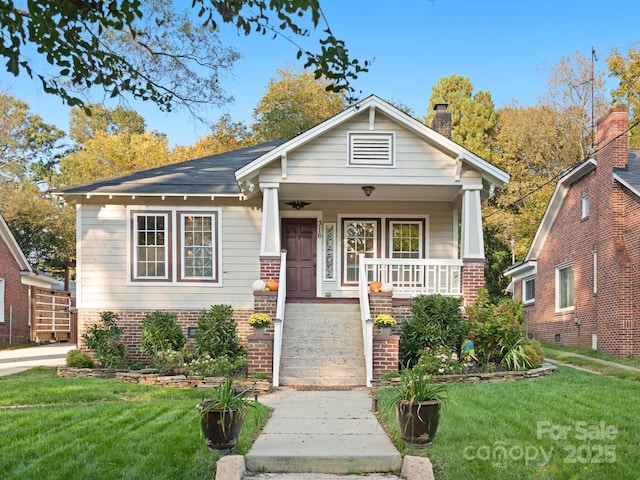 bungalow-style home with a porch and a front lawn