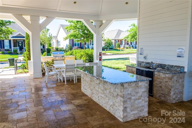 view of patio with area for grilling and sink