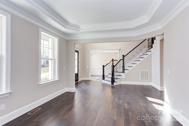 foyer entrance with stairs, visible vents, a raised ceiling, and dark wood-type flooring