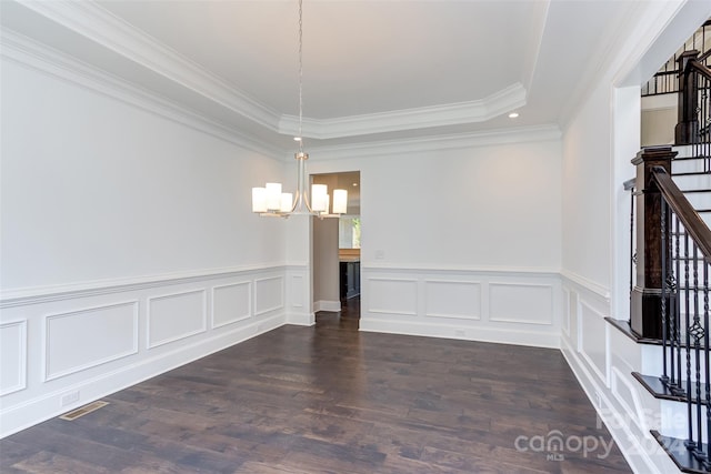 unfurnished room featuring an inviting chandelier, a raised ceiling, crown molding, and dark wood-type flooring