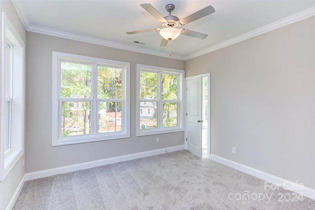 empty room featuring crown molding, light colored carpet, and a healthy amount of sunlight