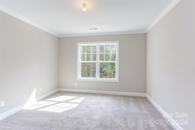 unfurnished room with carpet floors, crown molding, visible vents, and baseboards