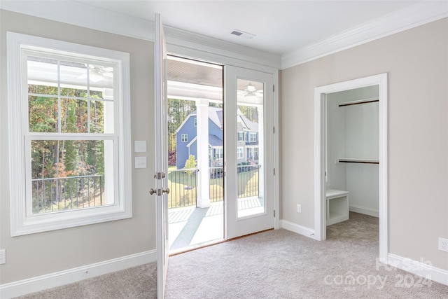 entryway featuring crown molding and light carpet