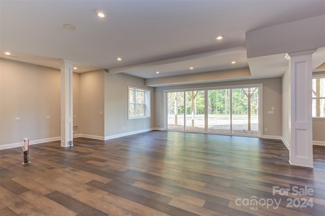 unfurnished living room with ornate columns and dark hardwood / wood-style flooring