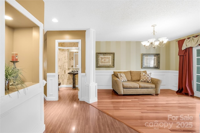 interior space with hardwood / wood-style floors, a textured ceiling, and a notable chandelier