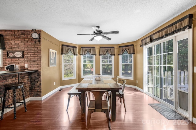 dining area with hardwood / wood-style floors, a wealth of natural light, a textured ceiling, and ceiling fan