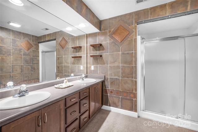 bathroom featuring vanity, a shower with shower door, and tile walls