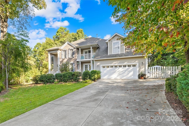 view of property with a garage, a front yard, and a balcony