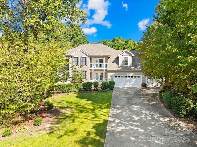 view of front of house with a garage, a front yard, and a balcony