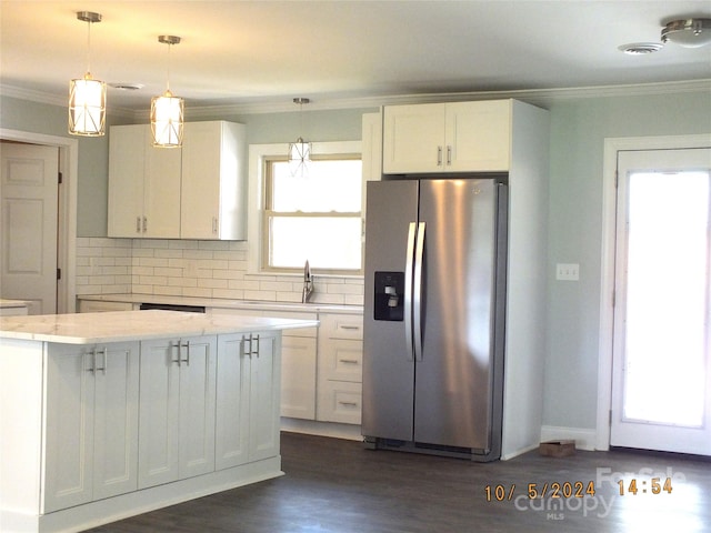 kitchen featuring pendant lighting, dark hardwood / wood-style floors, white cabinetry, crown molding, and stainless steel fridge