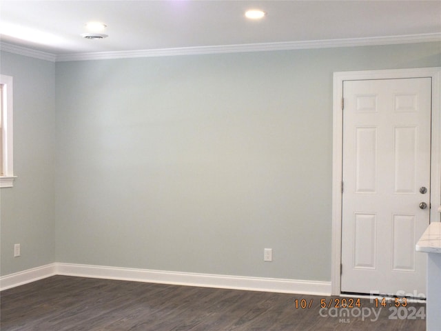 spare room featuring ornamental molding and dark hardwood / wood-style floors