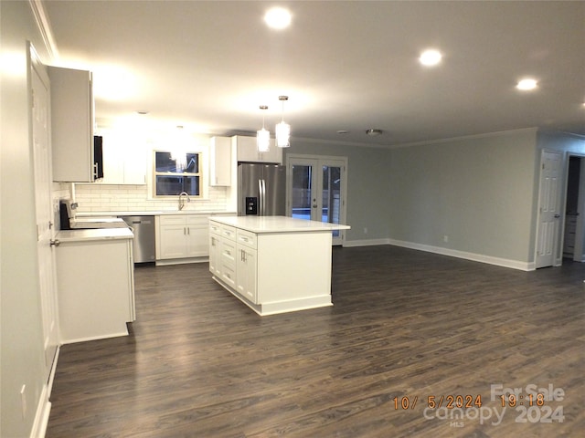 kitchen featuring white cabinets, a kitchen island, decorative light fixtures, dark wood-type flooring, and appliances with stainless steel finishes