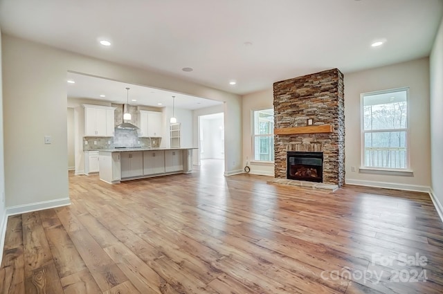 unfurnished living room featuring light wood-type flooring and a fireplace