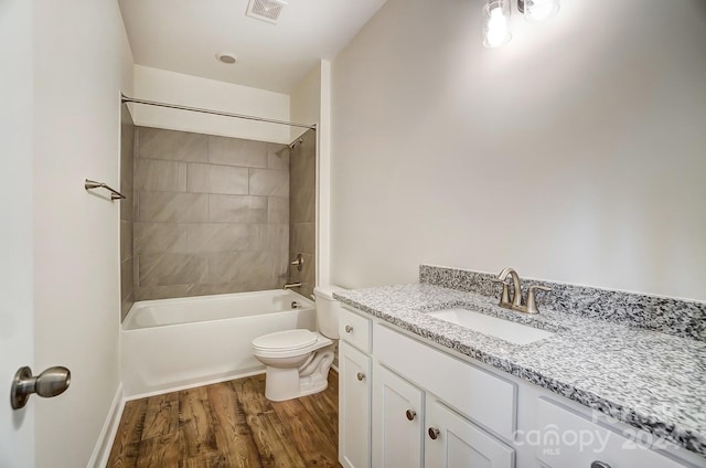 full bathroom featuring hardwood / wood-style floors, vanity, toilet, and tiled shower / bath