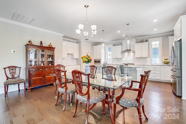 dining space with crown molding, dark wood-type flooring, and an inviting chandelier