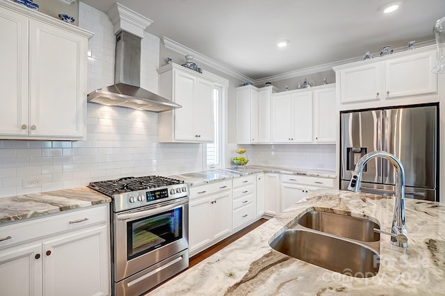 kitchen with stainless steel appliances, crown molding, wall chimney exhaust hood, and white cabinetry