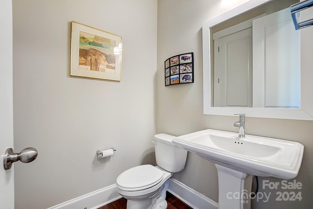 bathroom with hardwood / wood-style flooring and toilet