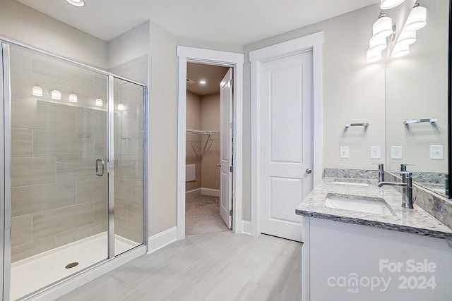 bathroom with a shower with door and vanity