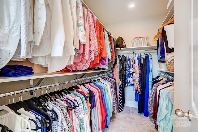 walk in closet featuring light carpet