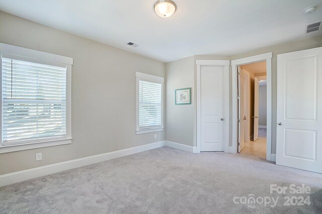 unfurnished bedroom featuring light colored carpet