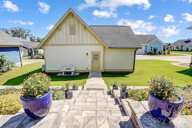 rear view of house featuring a lawn