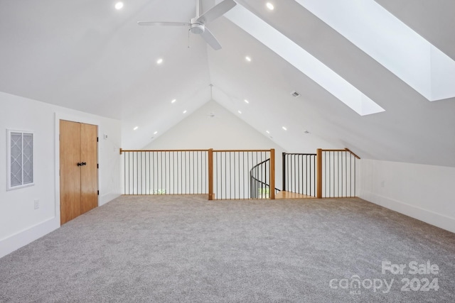 additional living space featuring carpet flooring, ceiling fan, and lofted ceiling with skylight