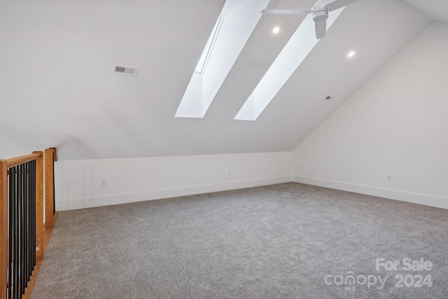 additional living space featuring vaulted ceiling with skylight and carpet flooring