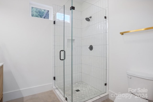 bathroom with vanity, toilet, and a shower with shower door