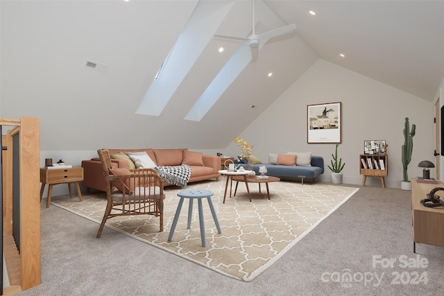 carpeted living room with ceiling fan and lofted ceiling with skylight