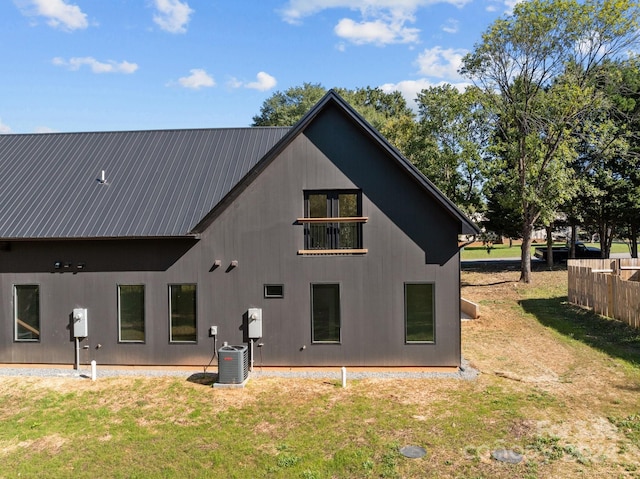 back of house with central AC and a yard